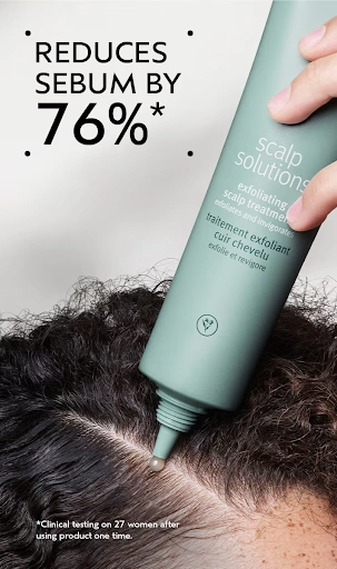 A hand applies a green bottle of scalp exfoliant to the parting of curly hair. Text says the product reduces sebum by 76% after one use, based on a clinical test with 27 women.